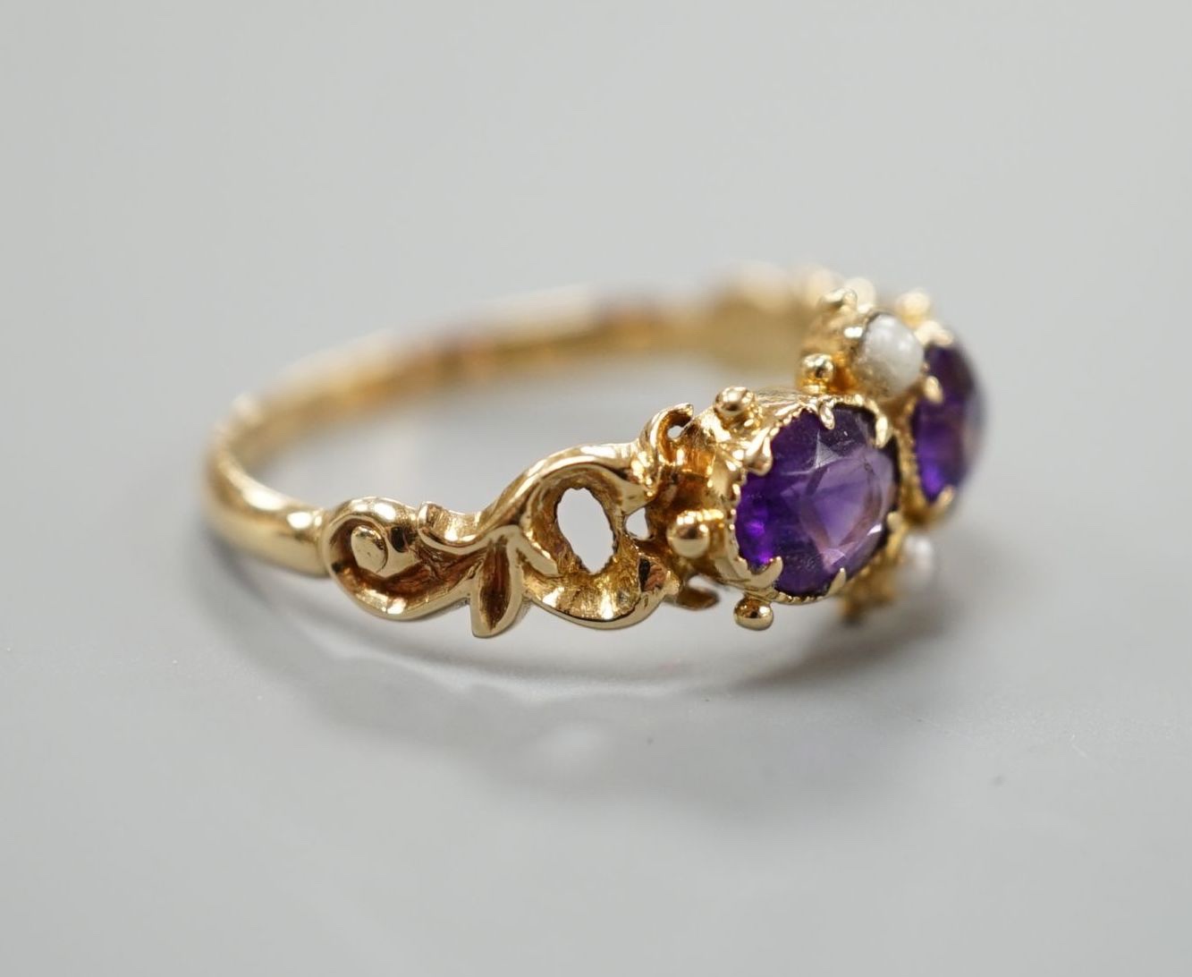 A late Victorian yellow metal, two stone amethyst and two stone seed pearl set cluster ring, size L, gross weight 2.1 grams.